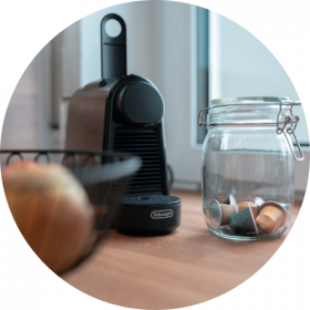 Kaffeemaschine mit einer handvoll Kaffeekapseln